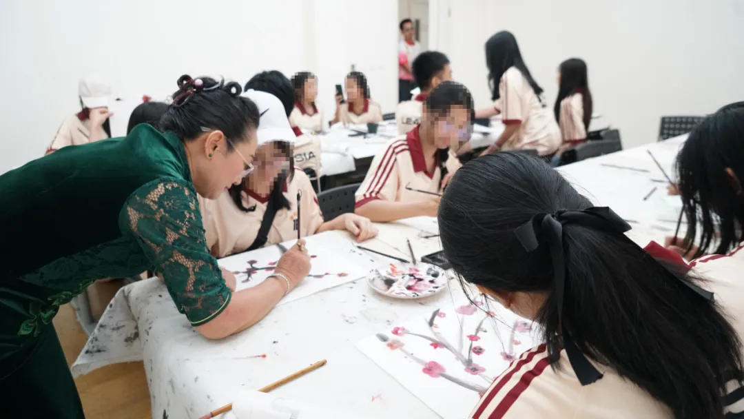 学生们在老师的指导下画国画