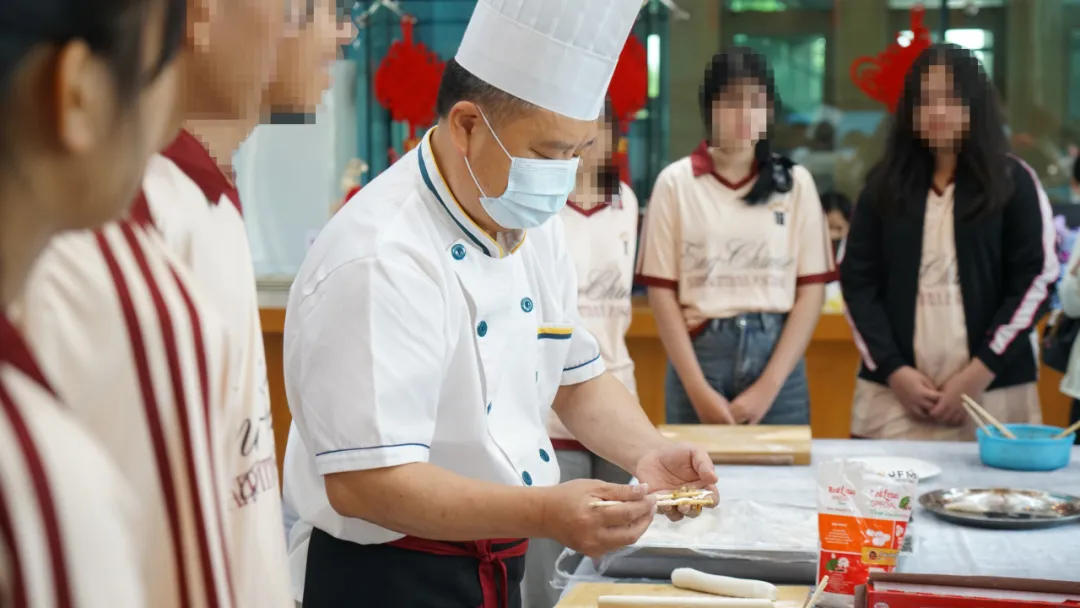 老师向学生们演示包饺子